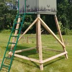 an 8 foot tall wooden tower stand holding a hunting blind on top