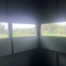 a view looking out into a field from the interior of a hunting blind